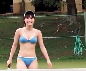 Japansk skjønnhet spiller bikini på tennisbanen